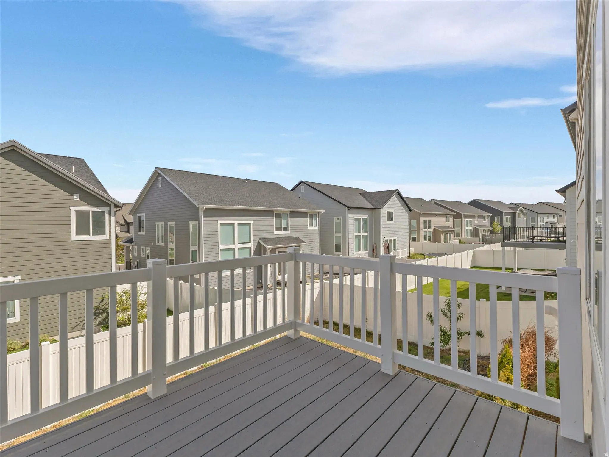 Elevated outdoor deck with a gray composite surface and white railing