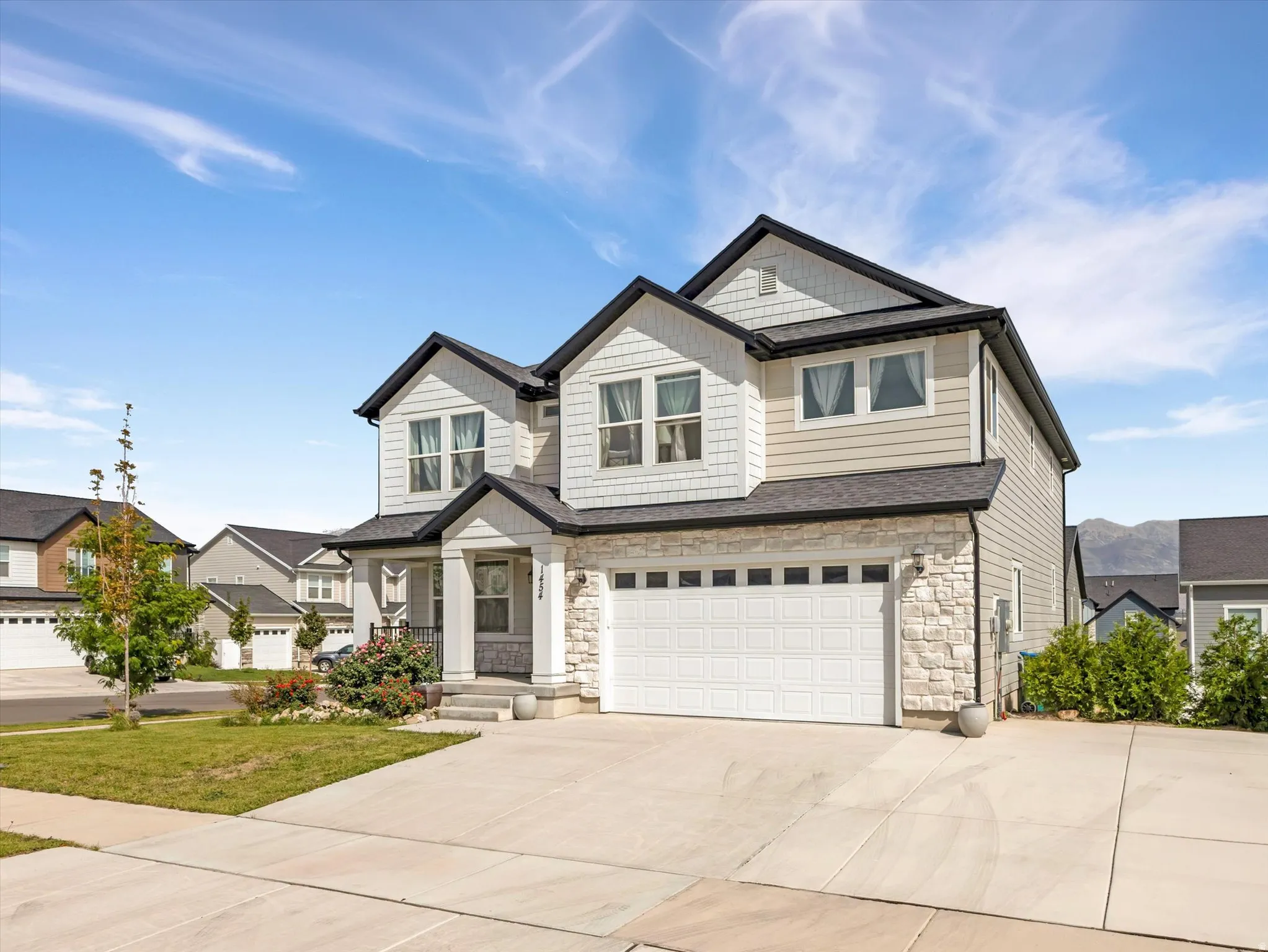 Two-story residence with a stone facade accent and horizontal siding