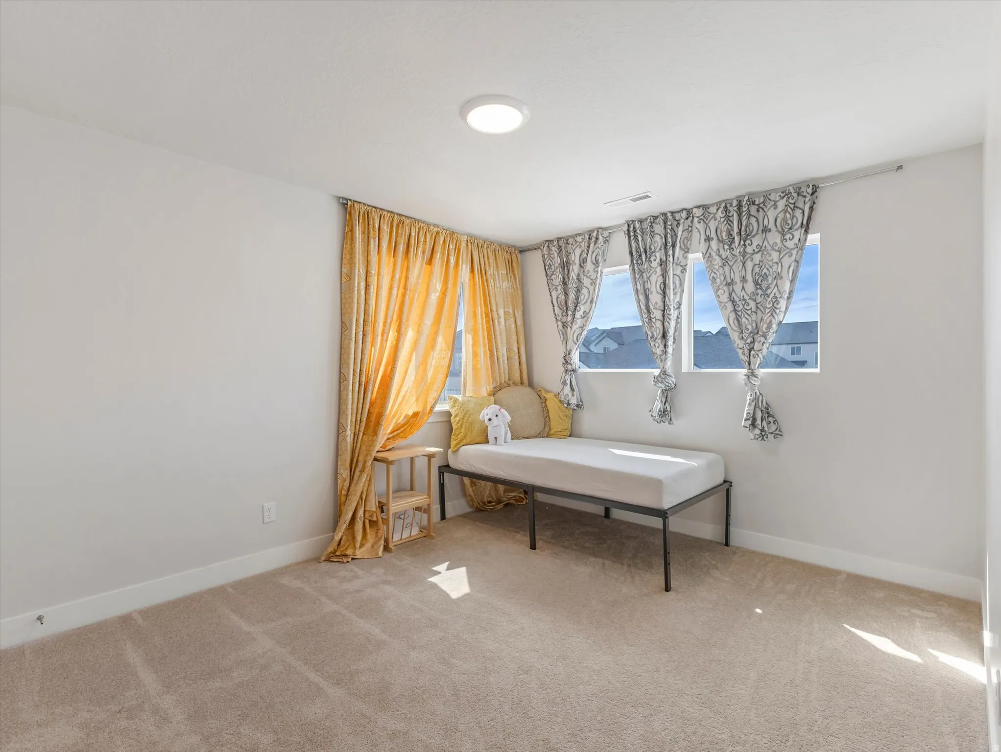 Carpeted room with multiple windows, an overhead light fixture, and light-colored walls