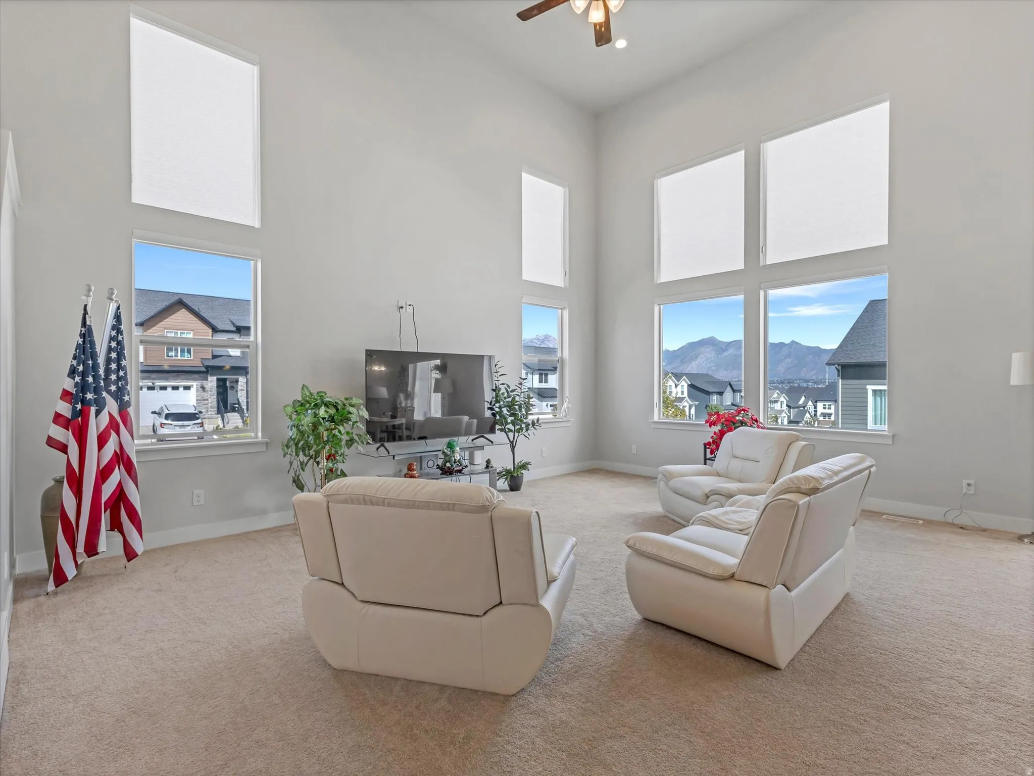 Soaring ceilings, large windows, mountain backdrop, and carpet flooring