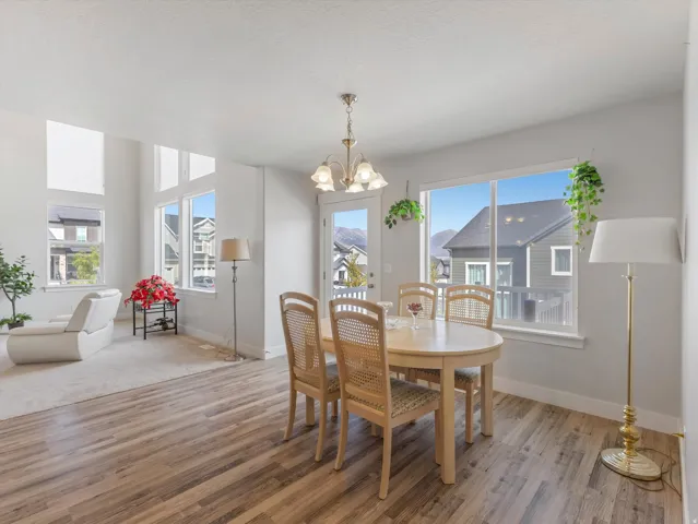 Expansive windows with transom accents, wood-finish flooring, recessed lighting, and a chandelier