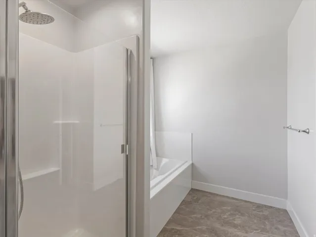 Walk-in shower with clear glass enclosure and built-in bench