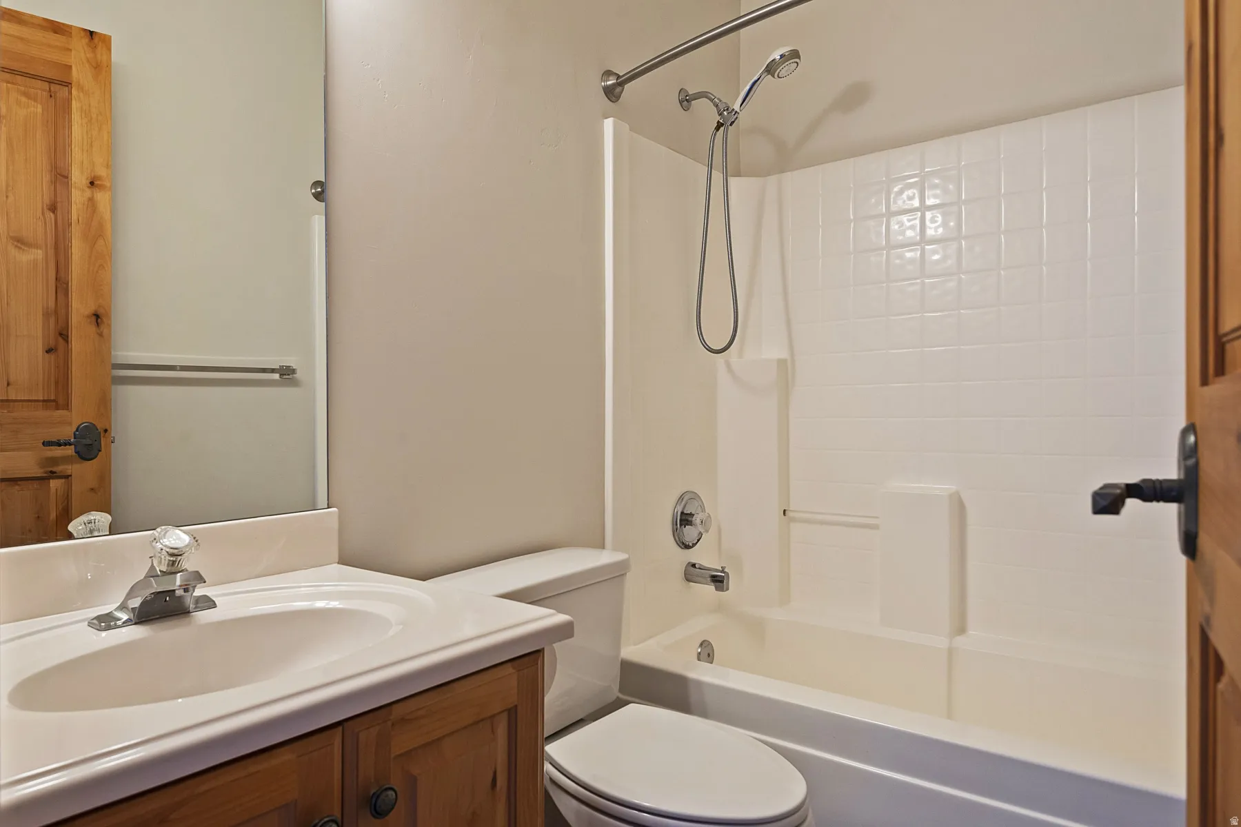 Vanity with integral sink, wood-finish cabinetry, and chrome fixtures