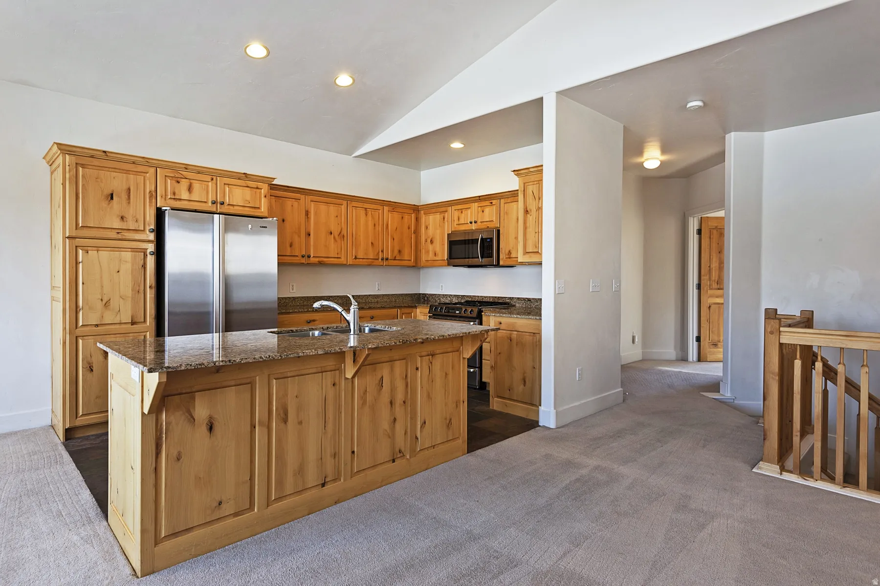 Kitchen featuring wood cabinetry, granite countertops, and stainless steel appliances