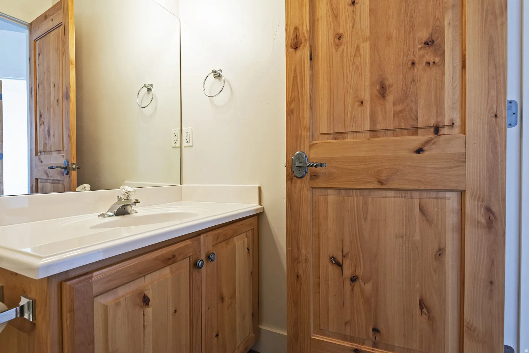 Single vanity with an integrated sink and light wood-finish cabinetry