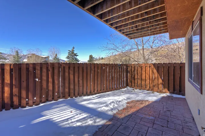 Stamped concrete patio with a privacy fence and exterior wall