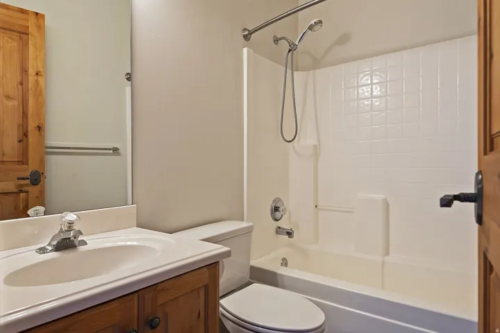 Vanity with integral sink, wood-finish cabinetry, and chrome fixtures