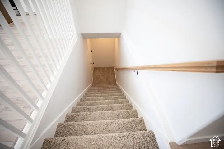 Fully-finished staircase leading to unfinished basement.