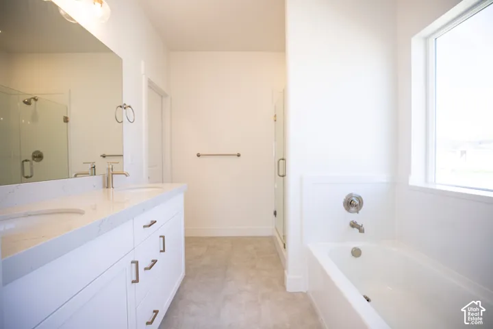 Primary bath with dual sinks, painted white wood cabinets, soaker tub and walk-in Euro shower.