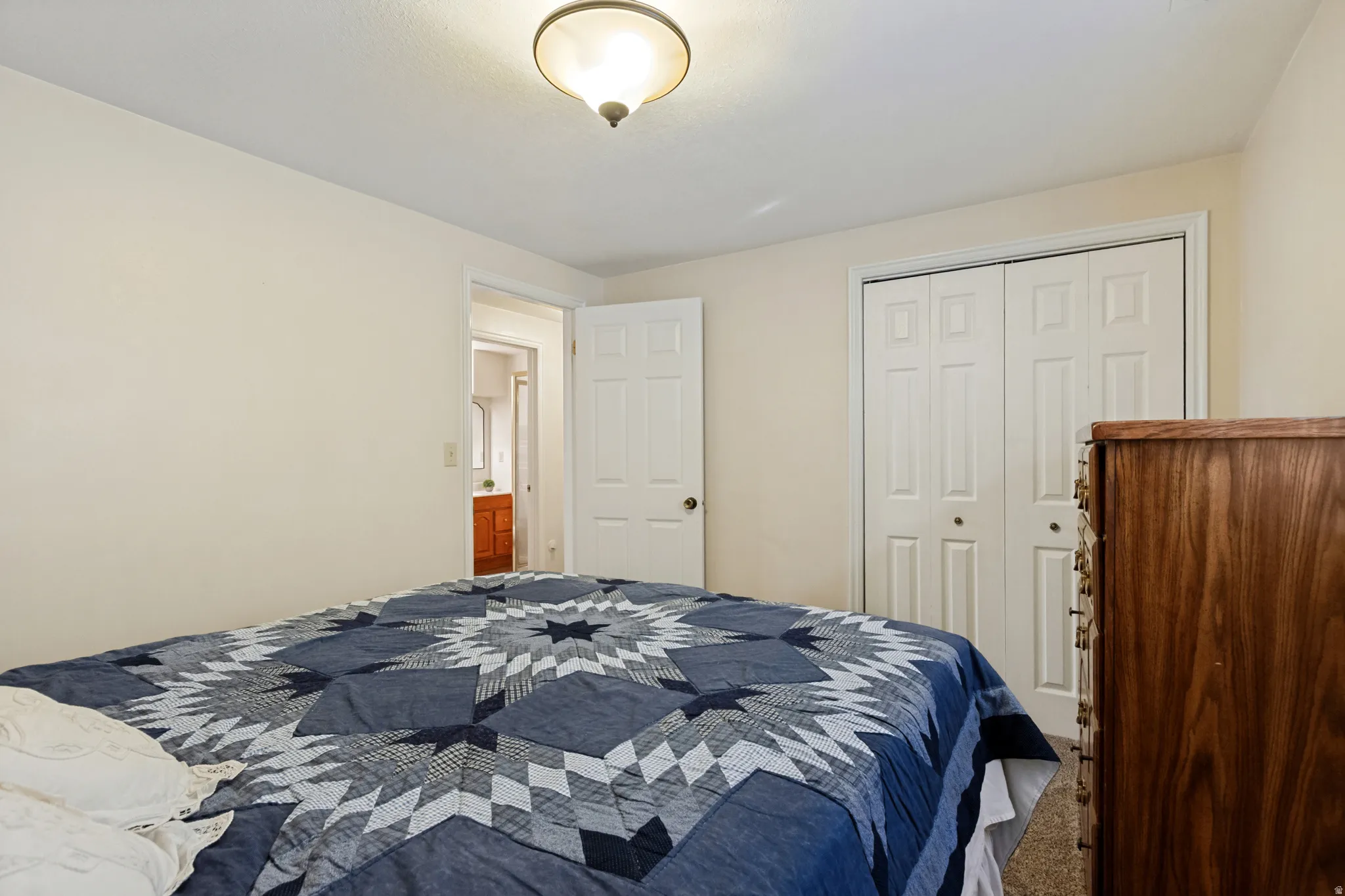 Recessed lighting fixture, paneled bi-fold closet doors, and light-colored walls