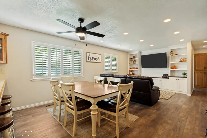 Wood-finish flooring throughout, multiple recessed lights, and a ceiling fan with integrated lighting