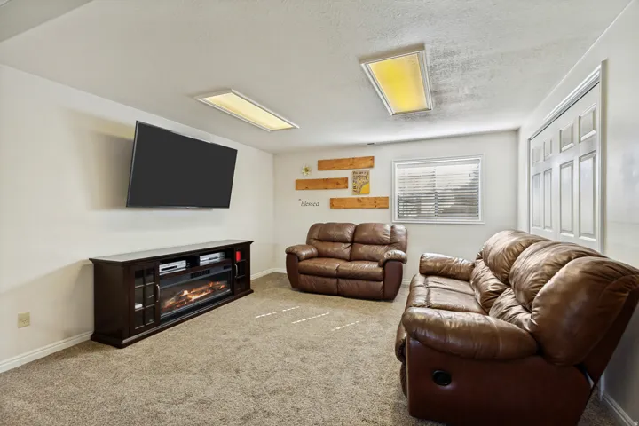 Carpeted room featuring a built-in fireplace console, a recessed window, and flush-mounted ceiling lighting