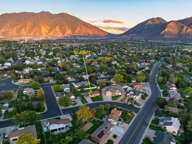 Residential neighborhood with mature trees and mountain backdrop