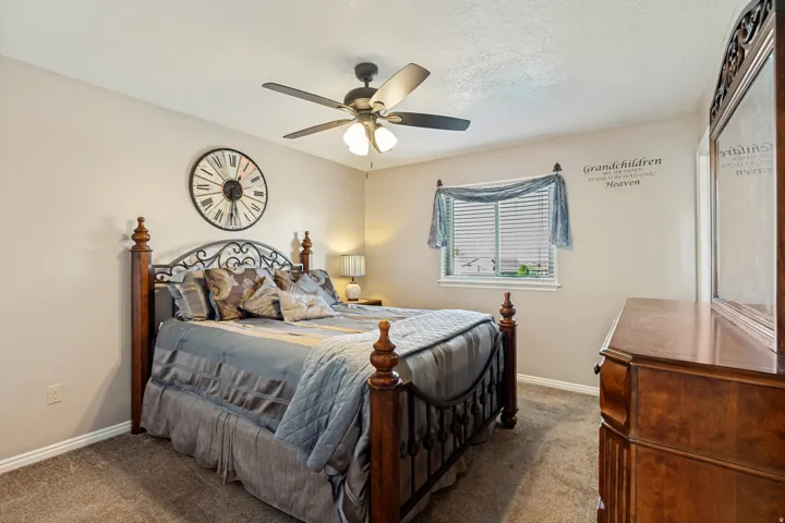 Ceiling fan, window with blinds, carpeted flooring, and neutral wall tones