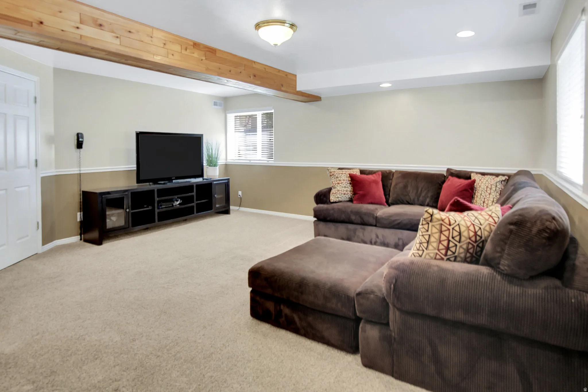 This room can be any room you would like it to be. Recessed lighting, wood-finish ceiling beam, wall-mounted light fixture, white interior door, and window with blinds
