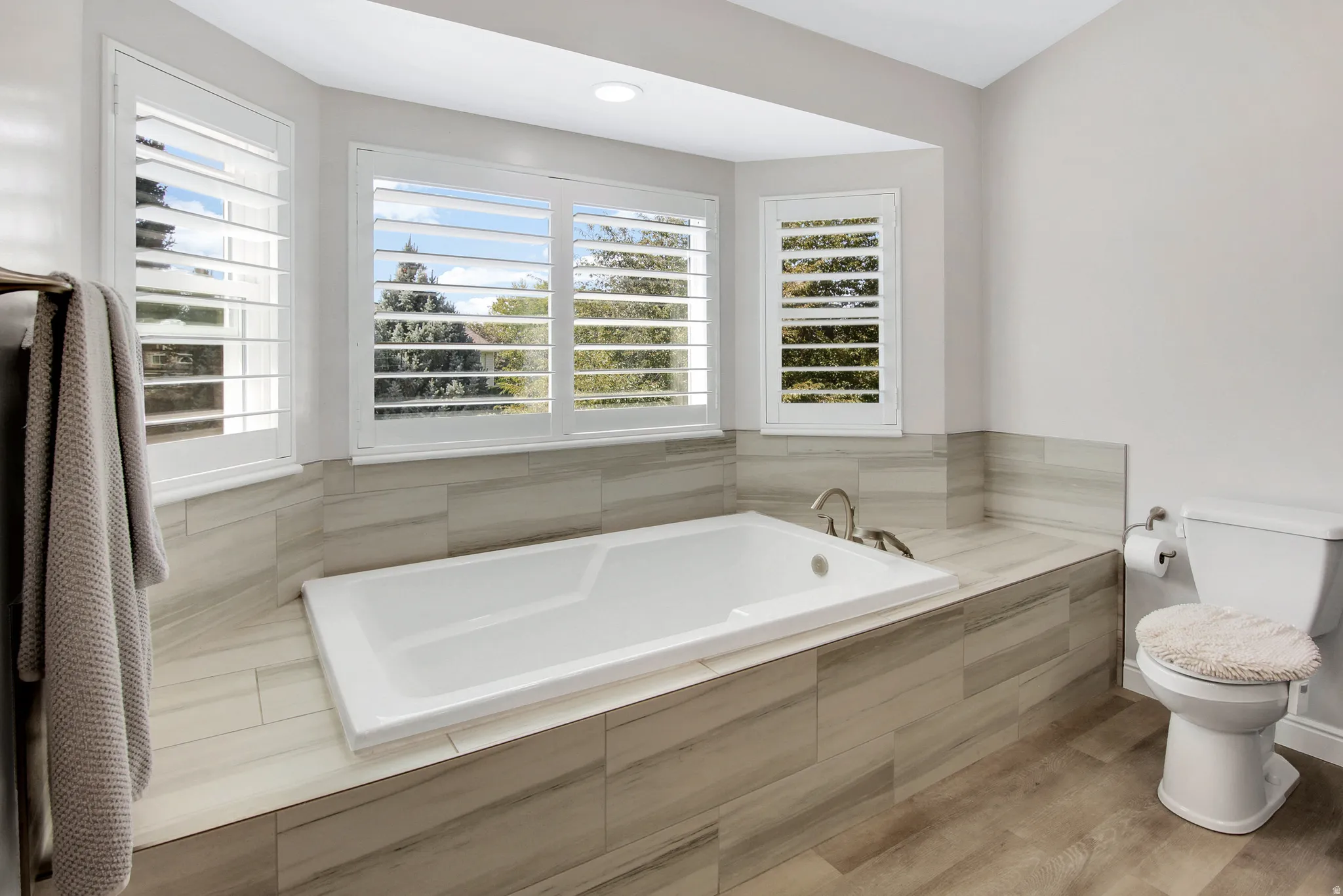 Primary Bath with Built-in soaking tub surrounded by beautiful tile and bay window.