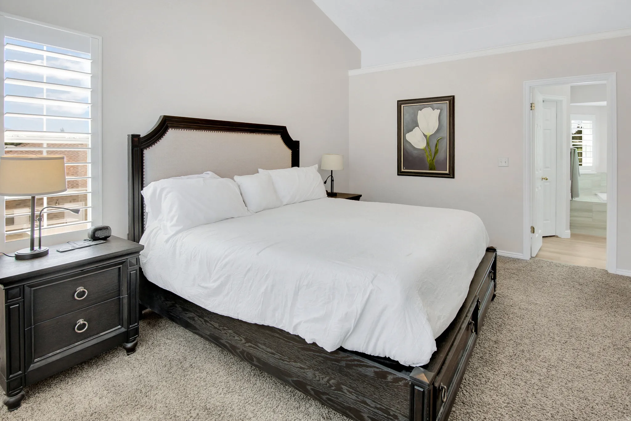 Primary Bedroom  mountain views, plantation shutters, and entrance into primary bath