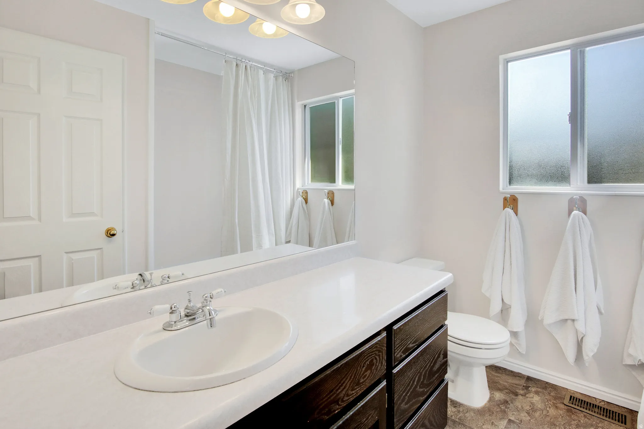 Upper main bathroom Vanity with white countertop, chrome faucet, and integrated sink