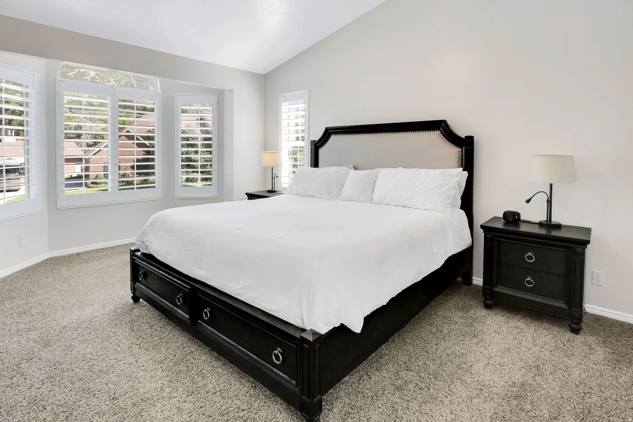 Primary Bedrooms with Vaulted ceiling, bay window, plantation shutters, and large walk in closet