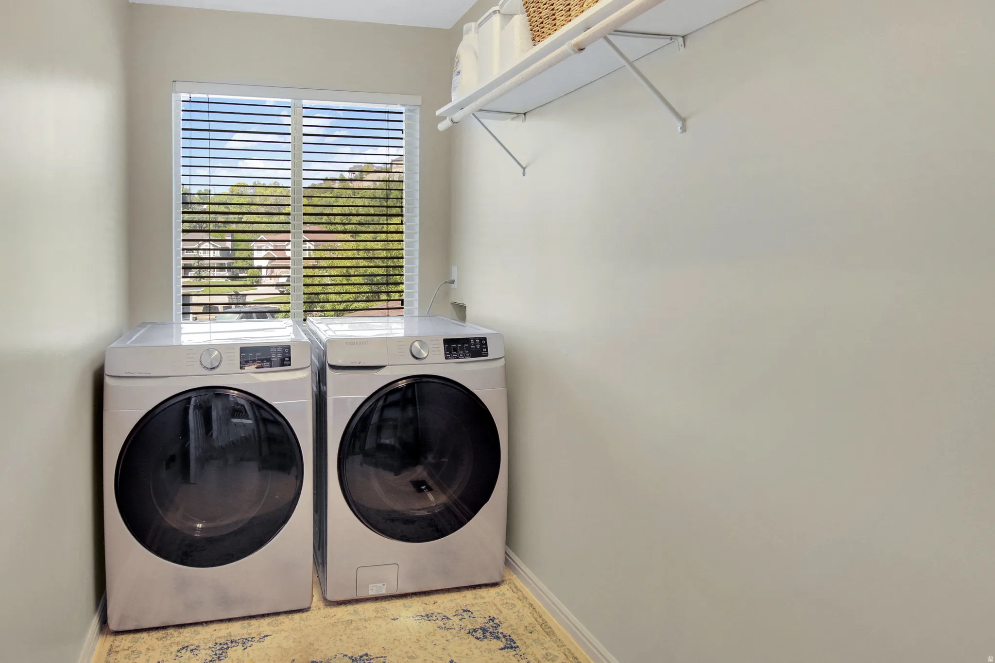 Third floor laundry room with Window with blinds, wall-mounted shelving.