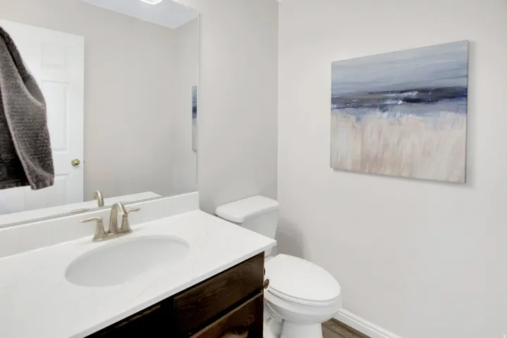 Half Bath located by great room. White solid surface countertop.