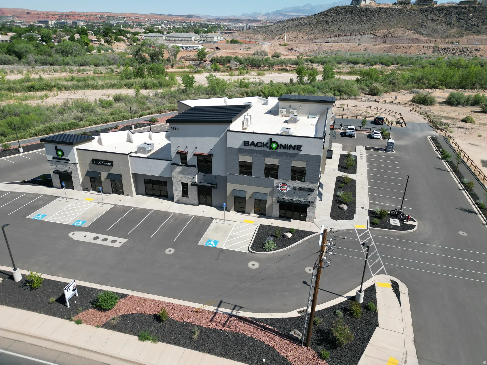 Modern commercial building with a multi-textured facade, ample paved parking, mature landscaping, and prominent retail storefronts