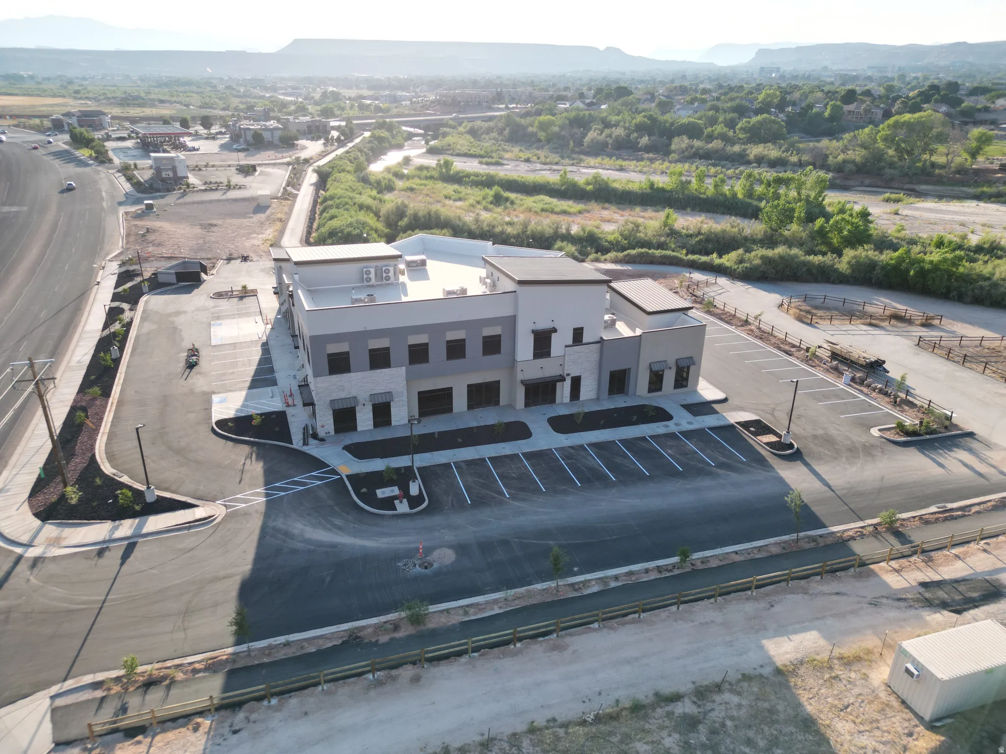 Modern commercial building with stone and stucco exterior, multiple window openings, and a flat roof
