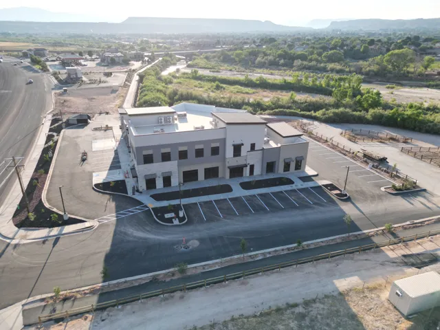 Modern commercial building with stone and stucco exterior, multiple window openings, and a flat roof