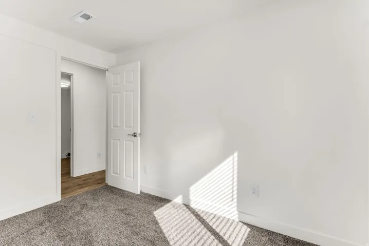 Neutral wall finishes, textured carpeting, and white trim