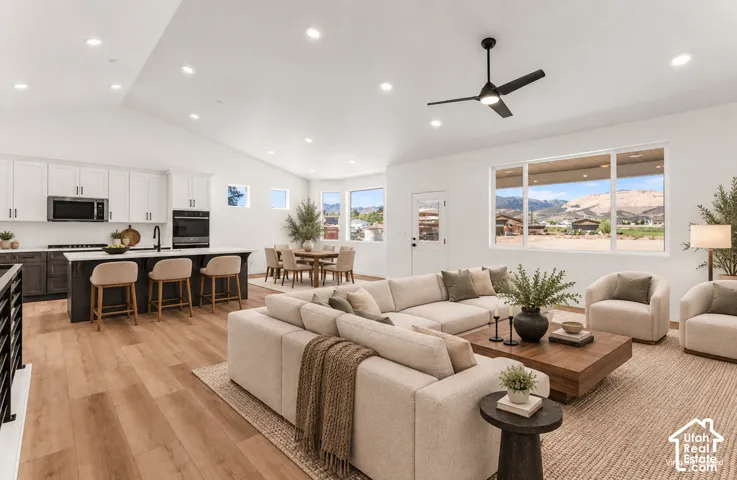 Open-concept living and kitchen featuring recessed ceiling lighting, a ceiling fan, and abundant natural light from expansive windows