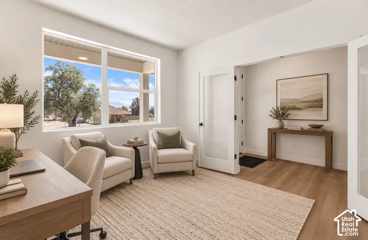 Spacious room with large windows, wood-finish flooring, and white interior doors with frosted glass panels
