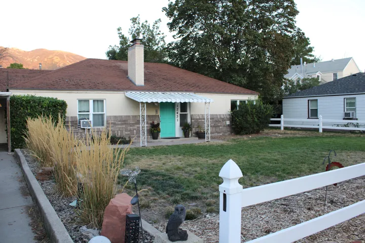 Ranch-style exterior with a brick and stucco facade, a prominent chimney, and a covered entry