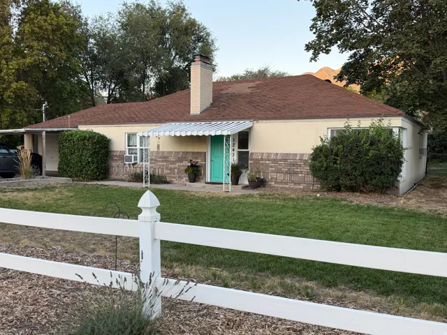 Single-story residence featuring a brick and stucco exterior, prominent chimney, and an attached carport