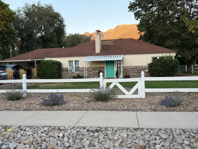 Brick and siding exterior with a white picket fence