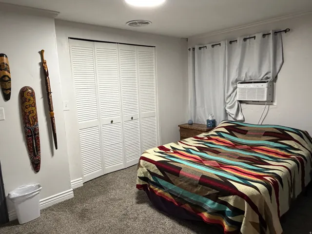 Wall-to-wall carpeting, louvered bi-fold closet doors, and recessed ceiling lighting