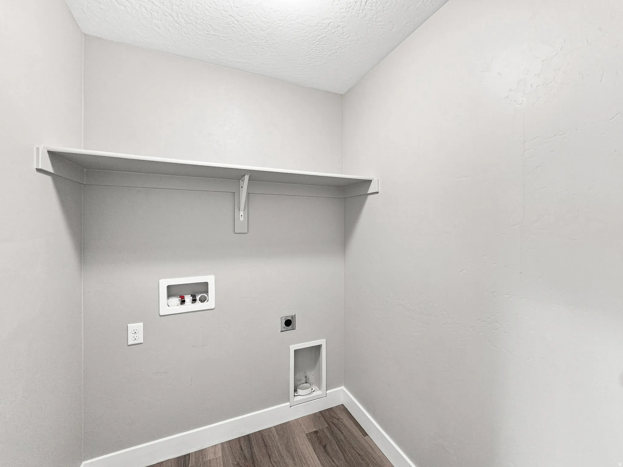 Utility area featuring wood-finish flooring and a built-in storage shelf