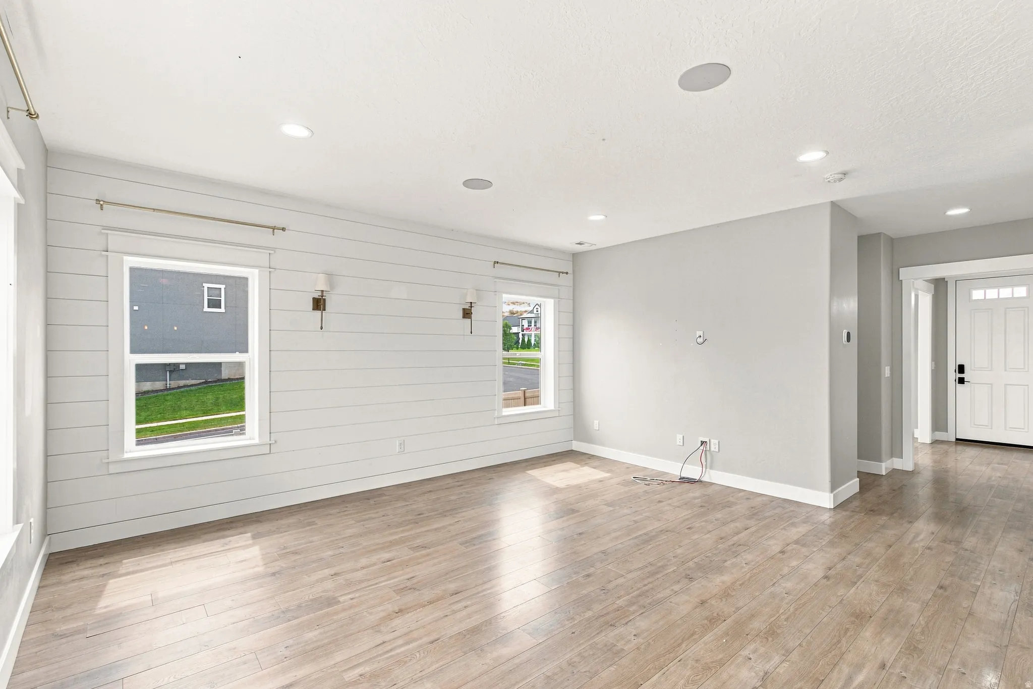 Spacious interior featuring wood-finish flooring, recessed lighting, and a prominent shiplap accent wall