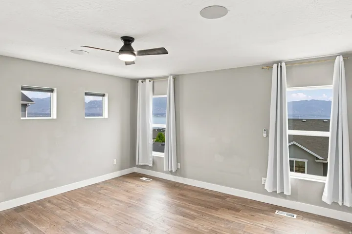 Wood-finish flooring, recessed ceiling speakers, and a ceiling fan with integrated lighting