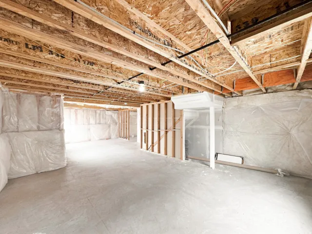 Unfinished basement featuring exposed joists, concrete flooring, framed wall sections, and insulated wall sections