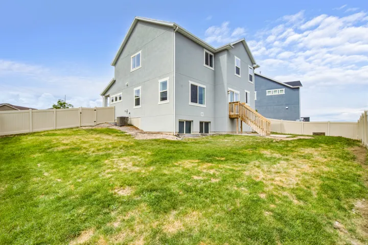 Expansive backyard with a sloped lawn and full perimeter fencing