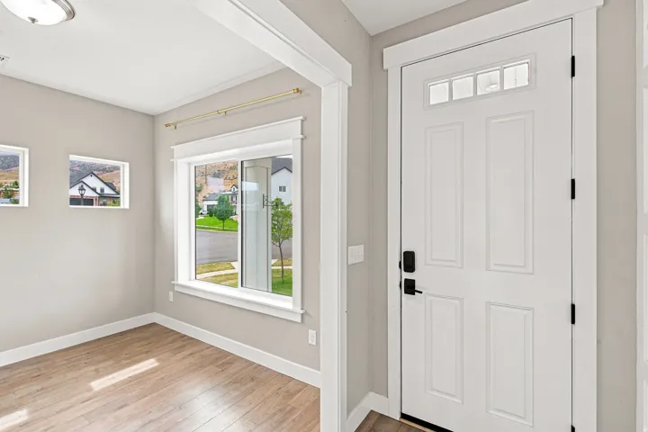 Front entry with a four-panel door, transom window, and matte black hardware
