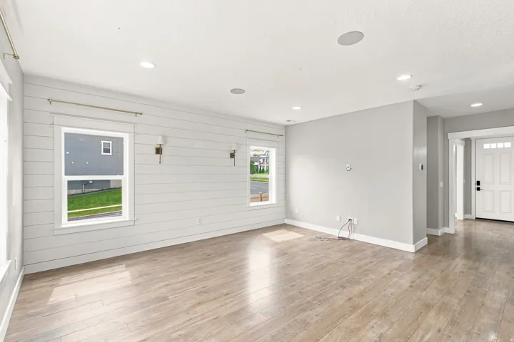 Spacious interior featuring wood-finish flooring, recessed lighting, and a prominent shiplap accent wall