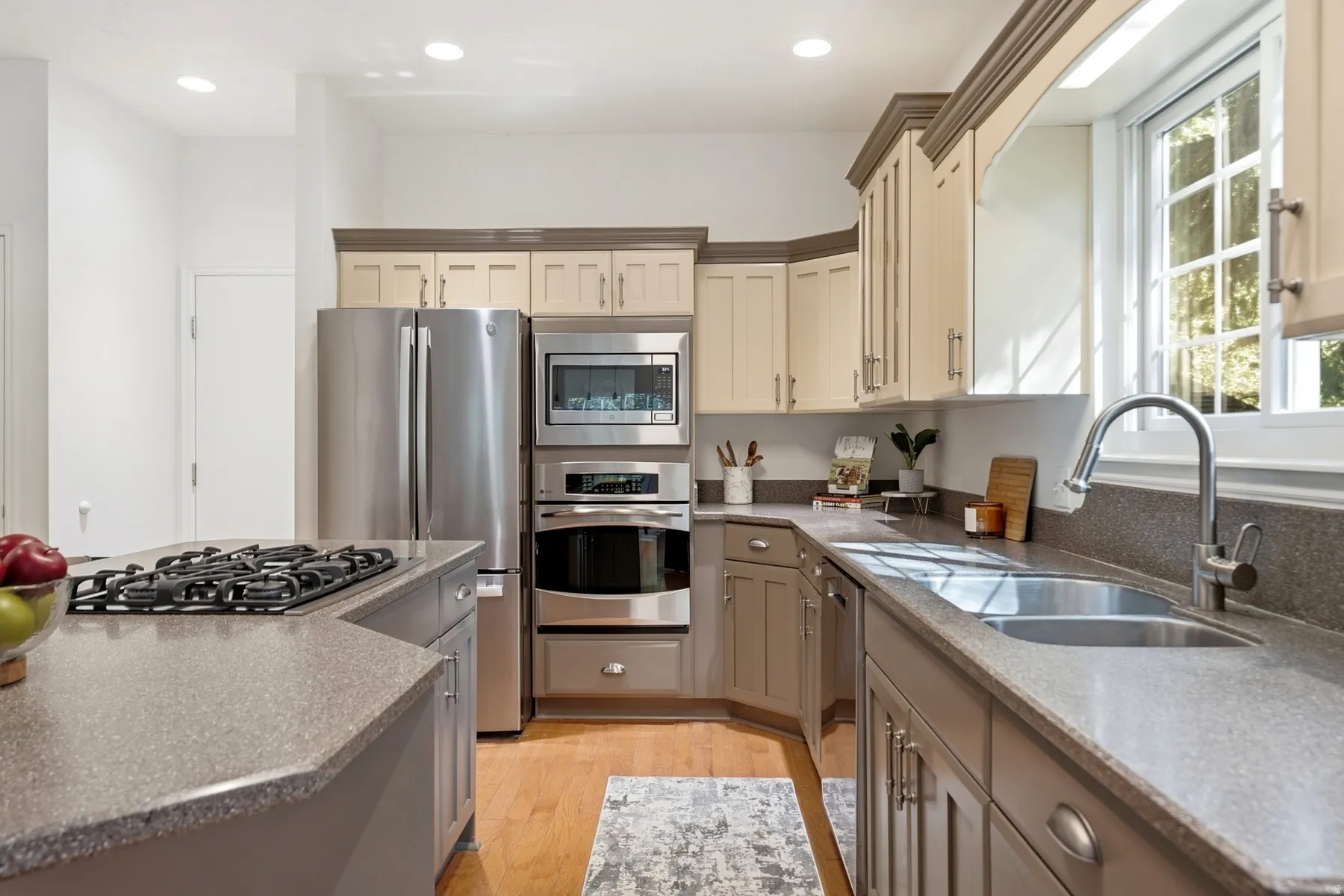 Kitchen featuring stainless steel appliances, dual-tone cabinetry, a built-in oven, a gas cooktop, and an undermount double-basin sink