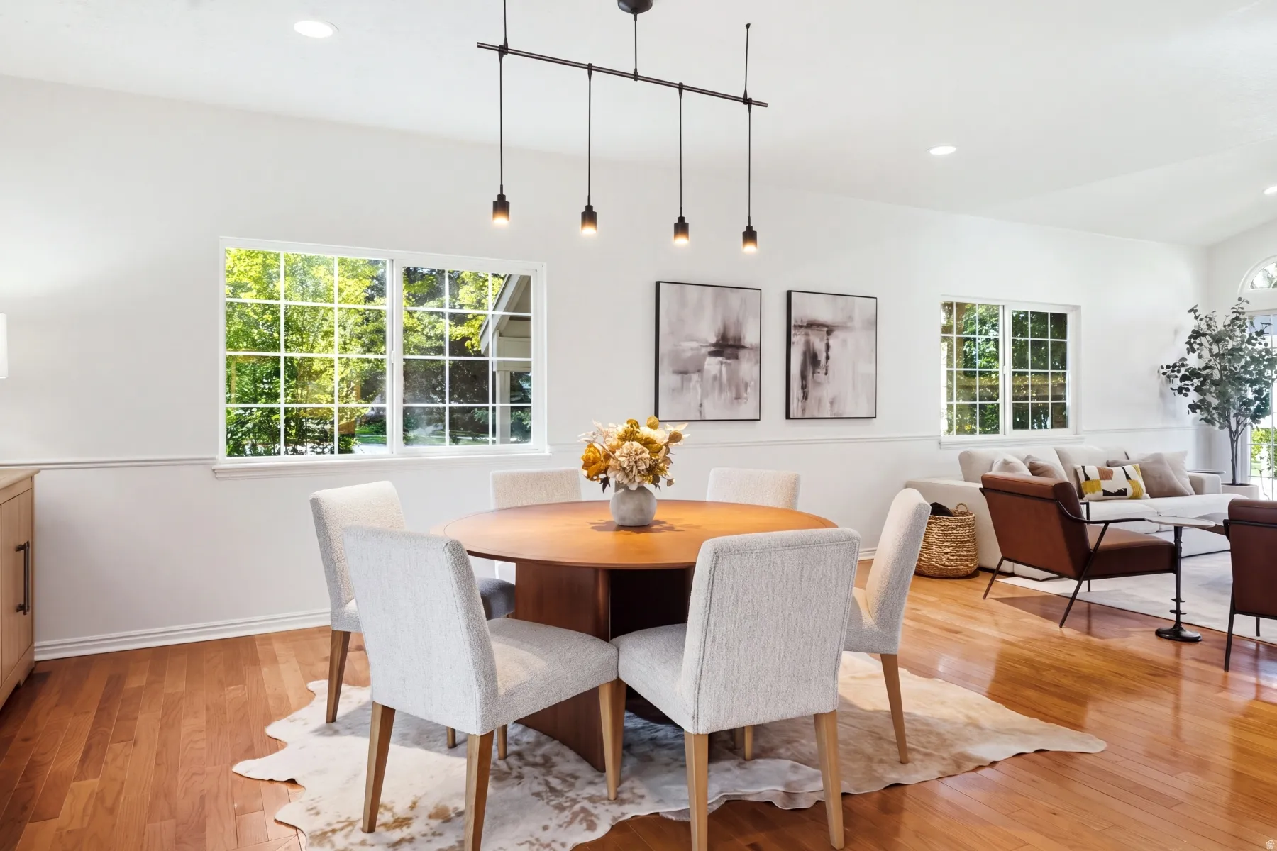 Hardwood flooring, recessed lighting, white walls, multiple windows, and a linear pendant light fixture