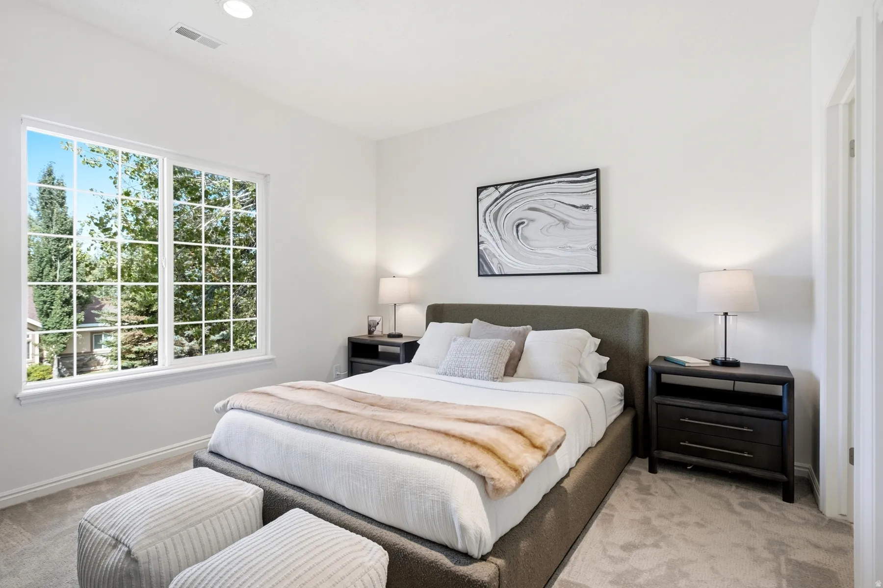 Expansive window with grid panes, recessed ceiling lighting, light neutral wall finishes, and light neutral carpet