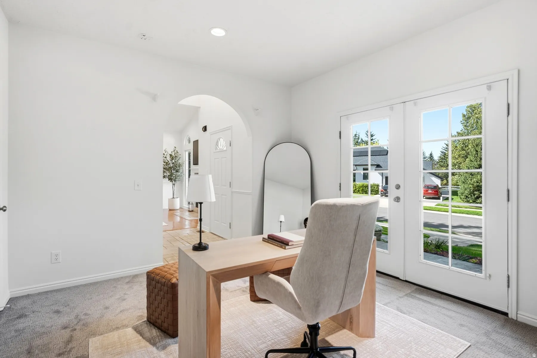 Room featuring an arched doorway, white trim, recessed lighting, and French doors with glass panels