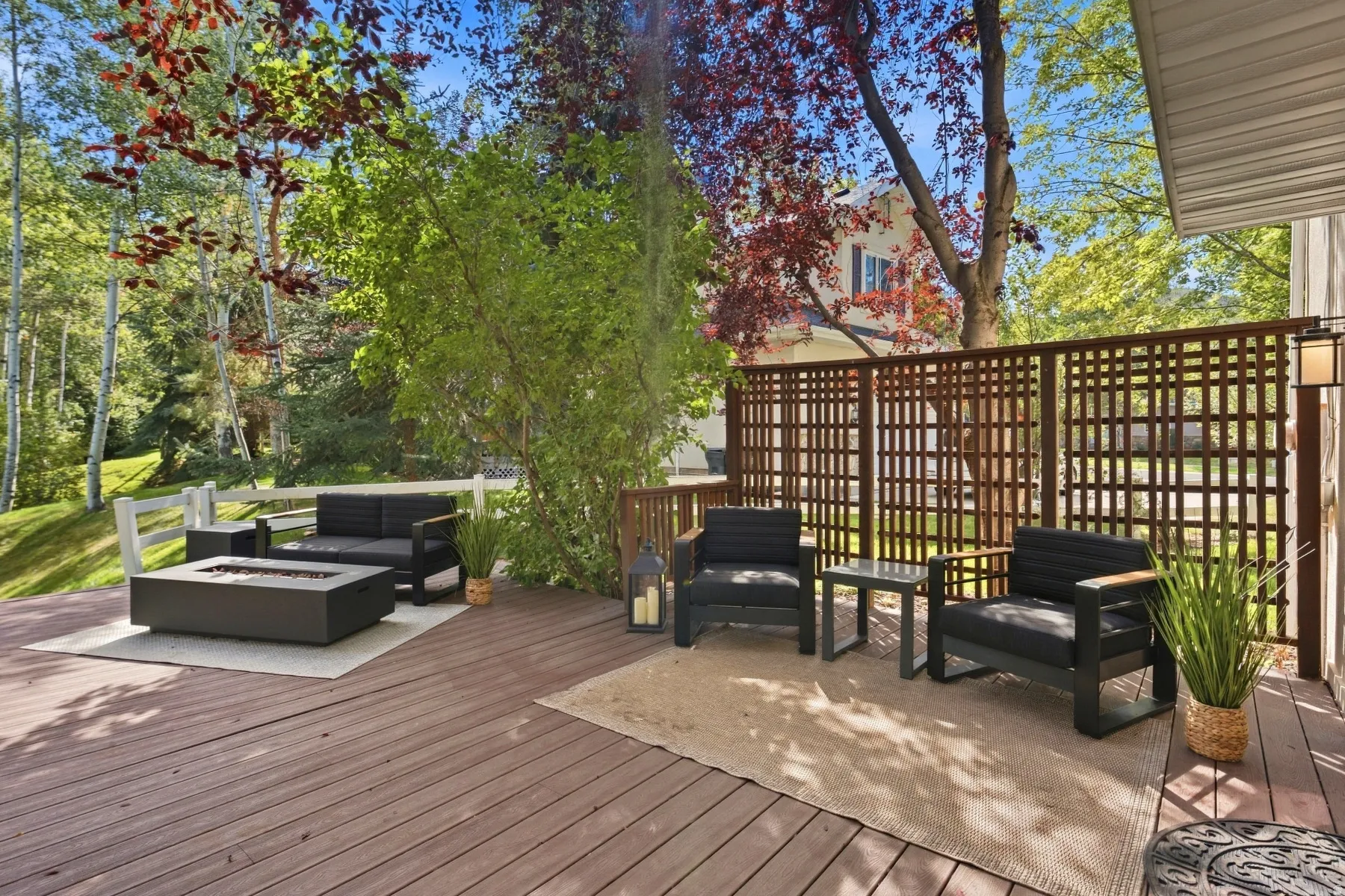 Spacious wood-finish deck with a lattice privacy screen and integrated outdoor lighting