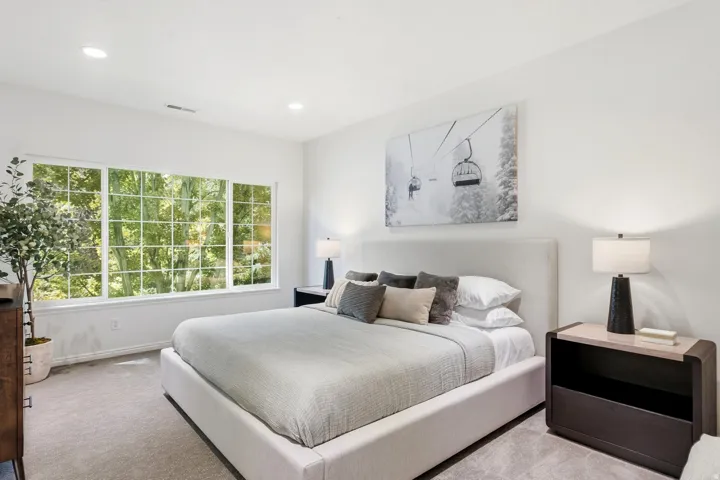 Light-filled room featuring a large multi-pane window, recessed lighting, and soft carpeting