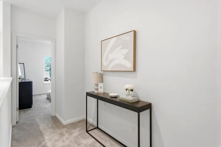 Carpeted hallway with white walls and trim