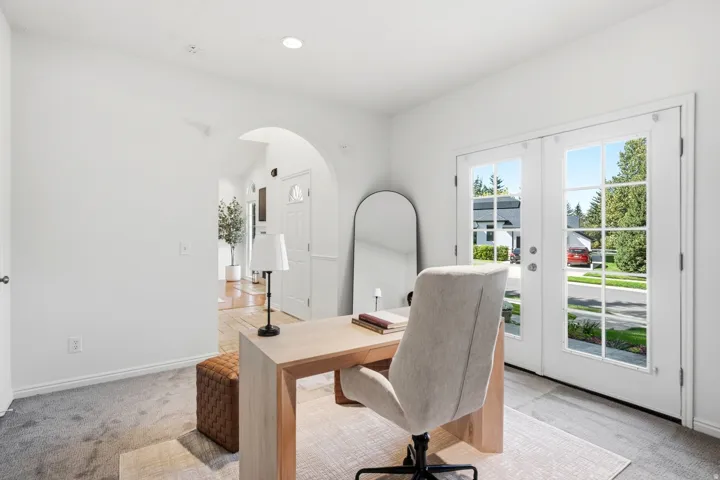 Room featuring an arched doorway, white trim, recessed lighting, and French doors with glass panels